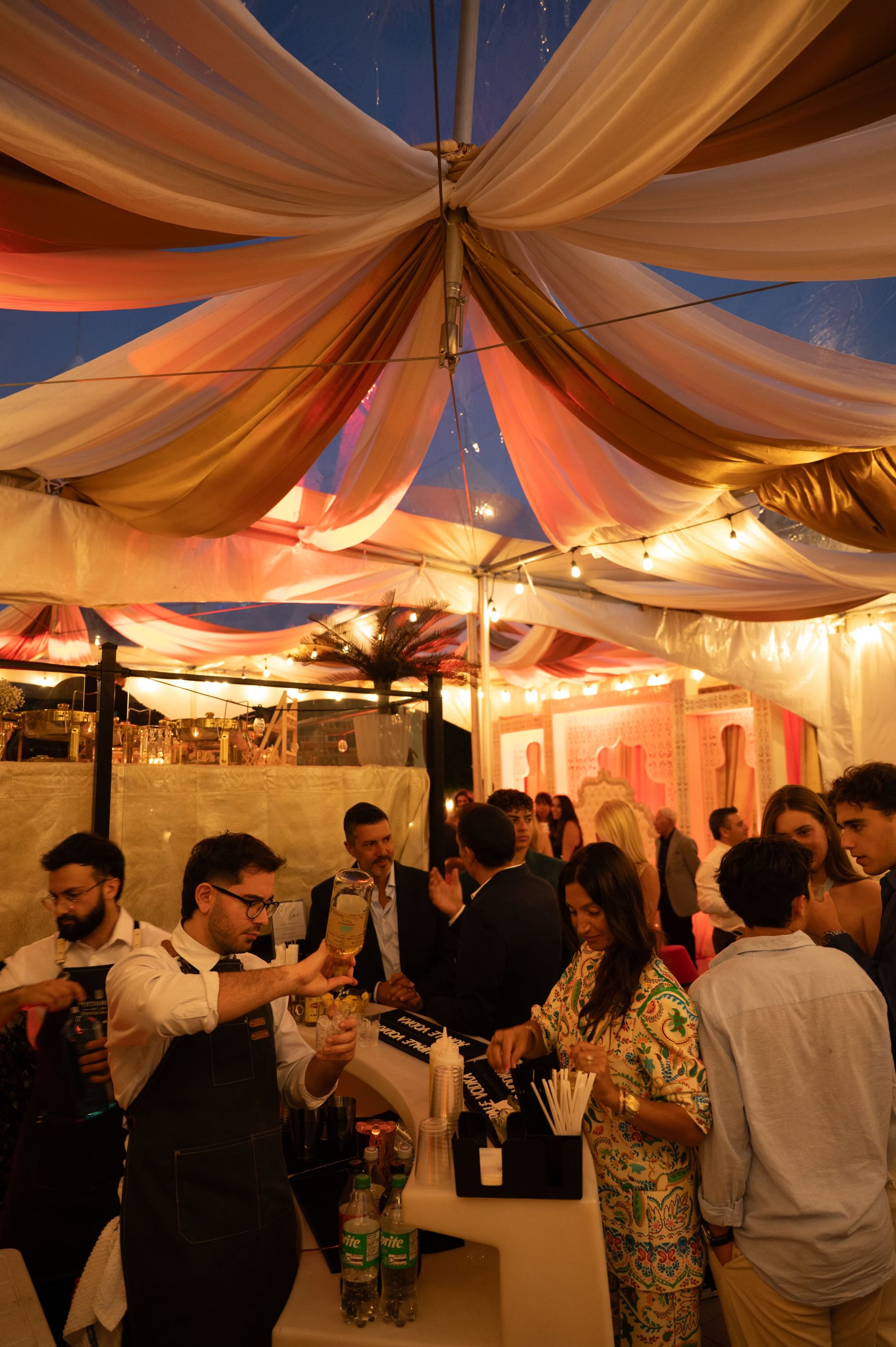 Outdoor evening event with fabric draped tent