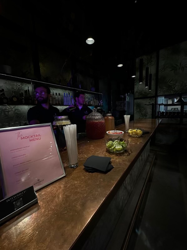 Intimate bar setting with mocktail menu and purple lighting